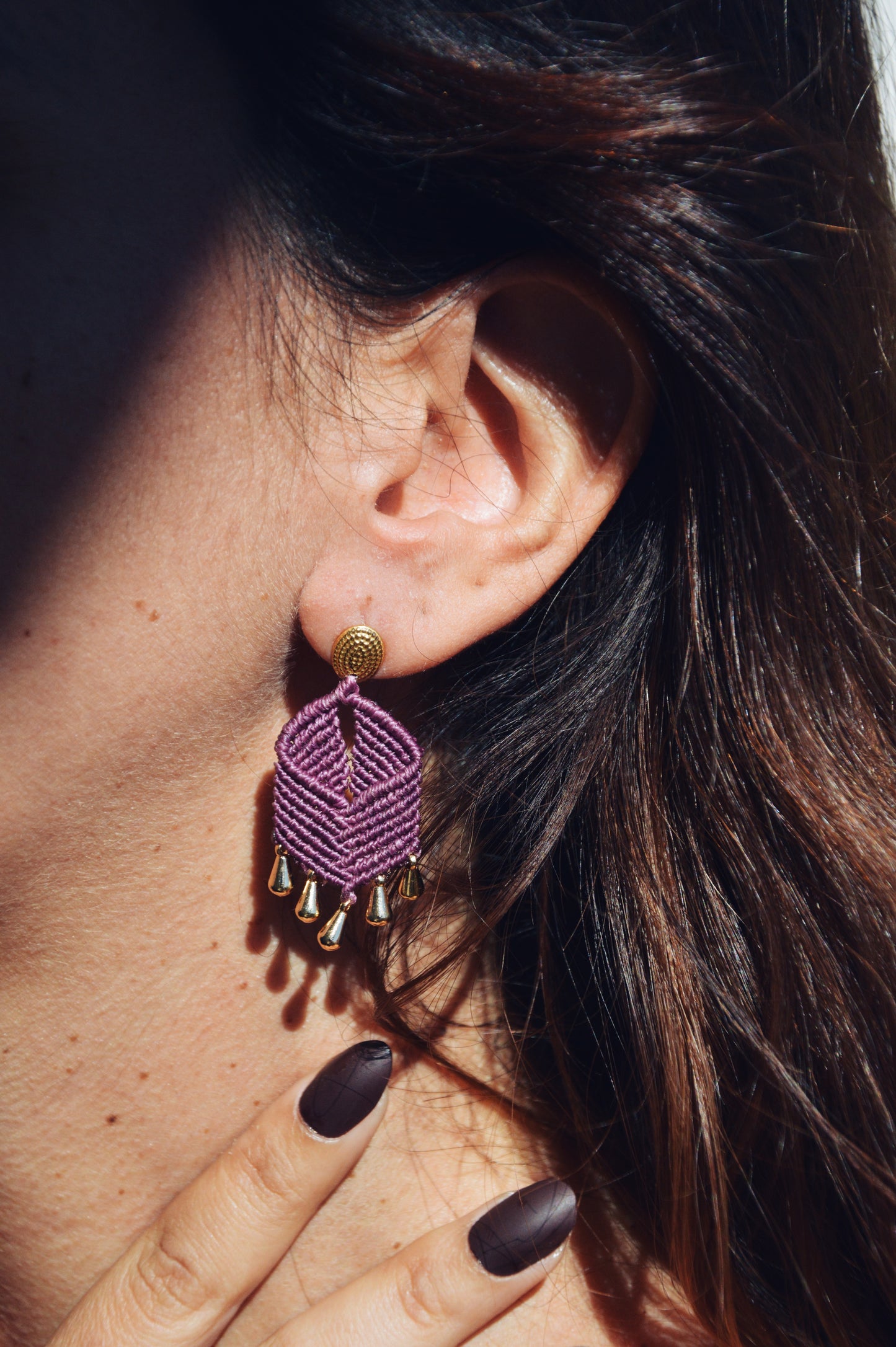 Girl wearing purple handmade macrame earrings with gold findings